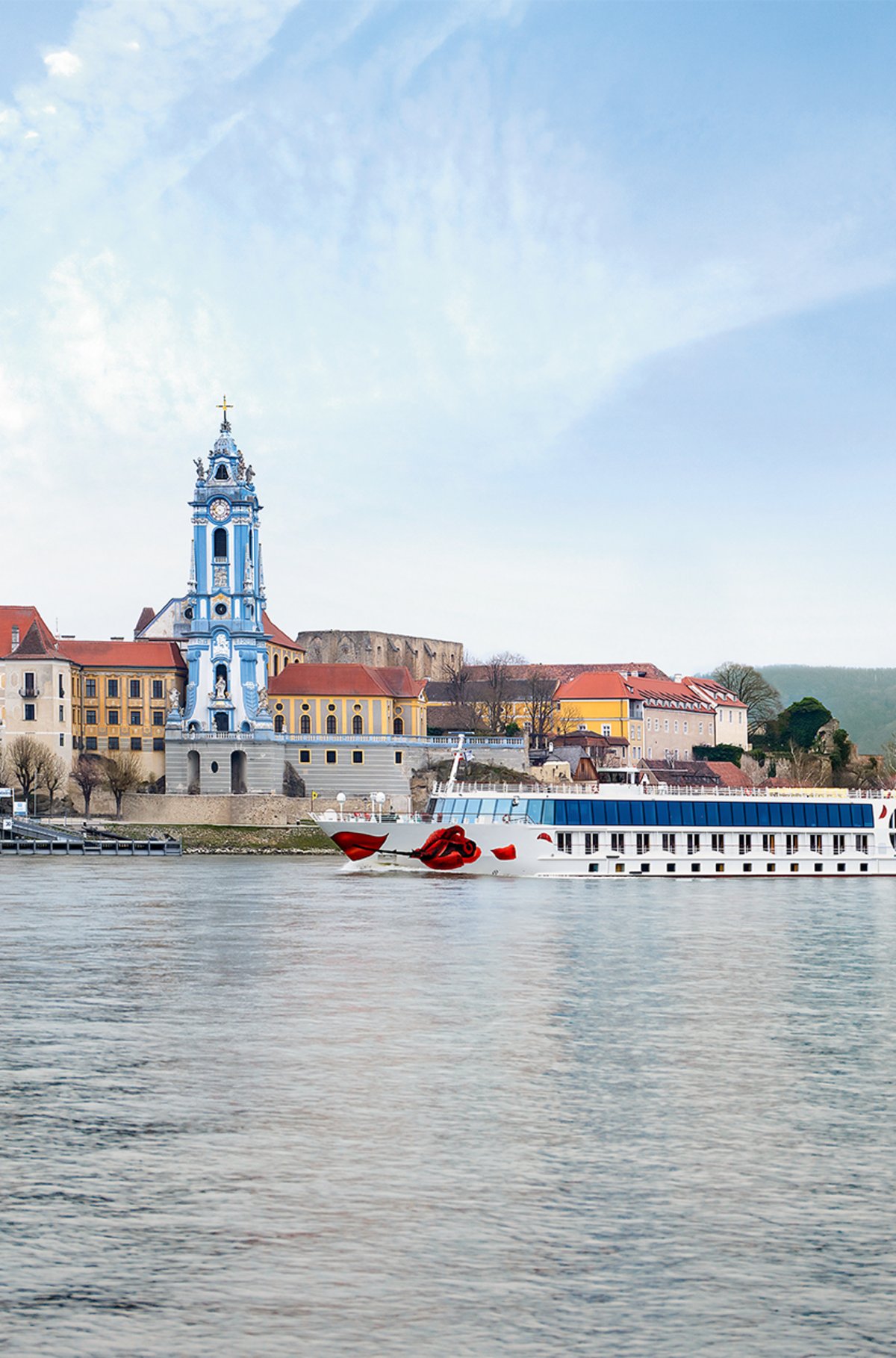 A-ROSA Flusskreuzfahrtschiff vor der Stiftskirche Dürnstein in der Wachau.
