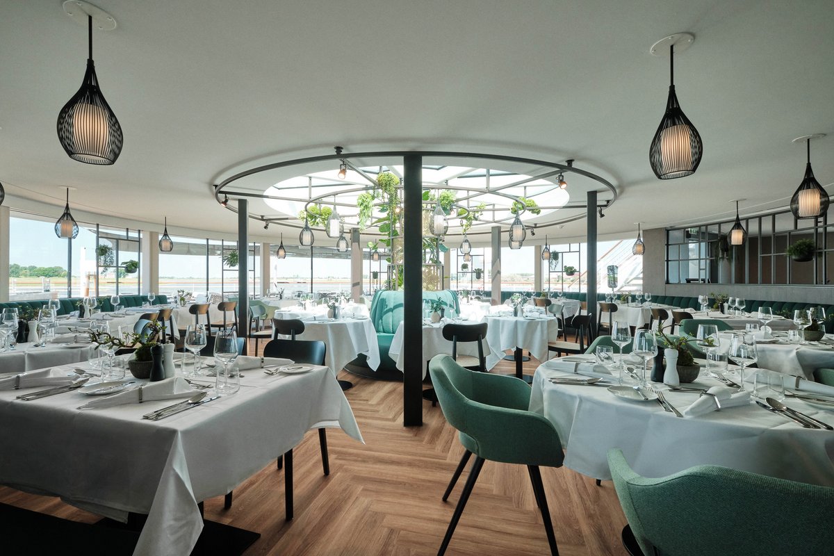 Stilvoll eingedeckter Restaurantbereich im PAVILION der A-ROSA SENA mit bodentiefen Fenstern und Blick auf einen ruhigen Fluss.